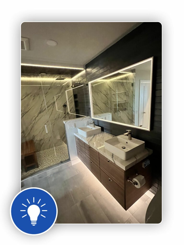 A modern bathroom in San Francisco with marble walls, two sinks, and illuminated mirrors.
